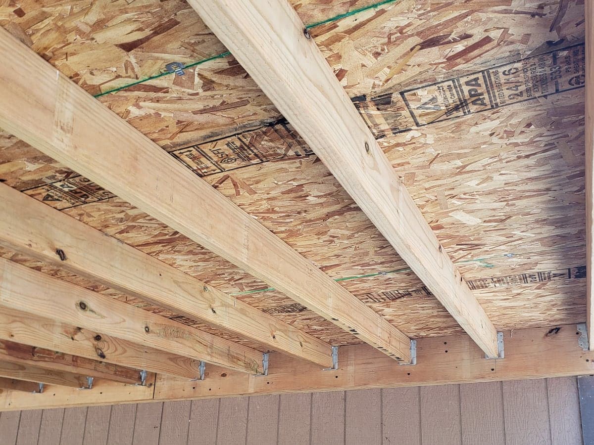 Timber deck framing with joists and support hardware visible from below.