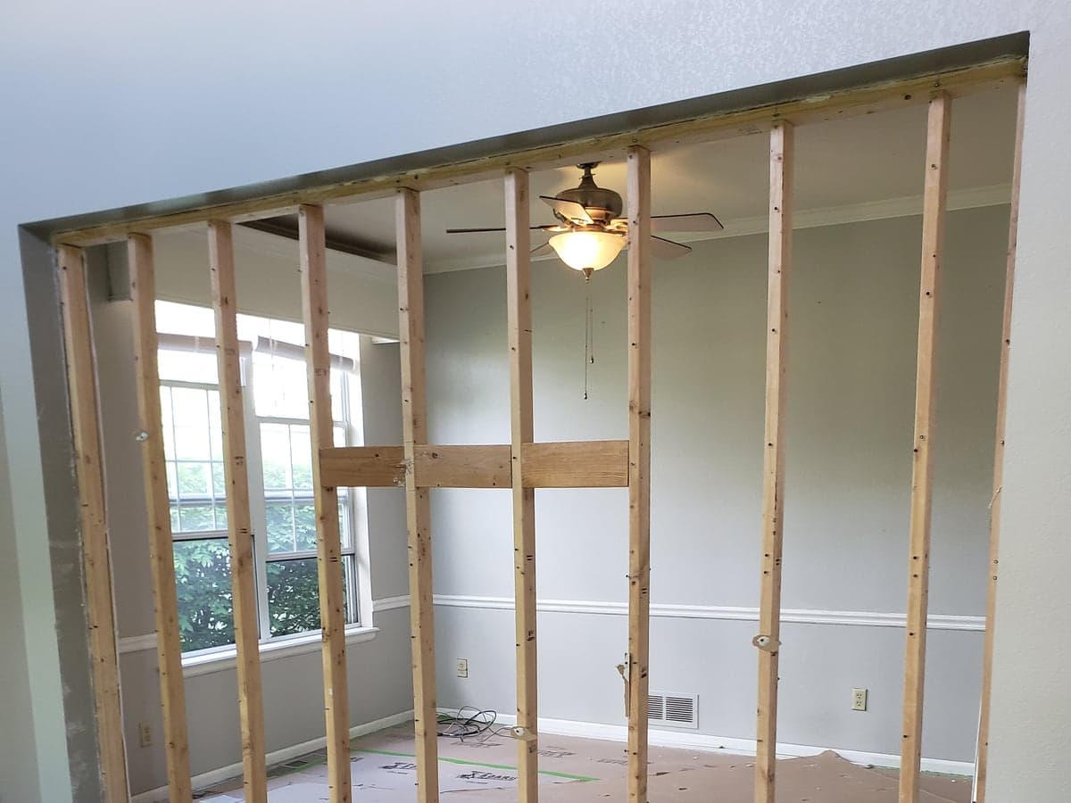 Interior wall opened to studs during a remodel with the flooring protected.
